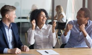 Excited african American husband and wife feel euphoric buy house together signing contract closing deal with Real Estate Agent, happy overjoyed black couple sit at banker office take property loan or mortgage